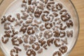 Top view of milk bowl, alphabet letters of cereal and chocolate flakes on wooden table, healthy Breakfast for kids and adults, Royalty Free Stock Photo