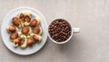 Top view. Milk and white chocolates in the form of seashells on a white plate and coffee grains in a coffee cup. Royalty Free Stock Photo