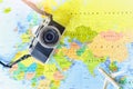 Top View of Miniature Airplane and Vintage Mirrorless Camera on World Map Background