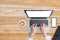 Top view minimal workspace, Woman hand working on laptop and smartphone with white screen,with coffee cup, notebook,on wooden desk Royalty Free Stock Photo