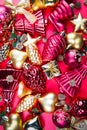 A top view of mixed golden and red Christmas ornaments on red background