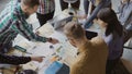 Top view of mixed race group of people standing near the table. Young business team working on start-up project together Royalty Free Stock Photo