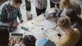 Top view of mixed race group of people standing near the table. Young business team working on start-up project together Royalty Free Stock Photo