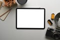 Top view of digital tablet with empty screen, notebook, camera and coffee cup on photographer workplace. Royalty Free Stock Photo