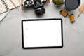 Top view of digital tablet with white screen, camera, coffee cup ans notebook on marble background. Royalty Free Stock Photo