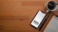 Top view of mock up smartphone, clipboard, coffee cup and copy space on wooden table