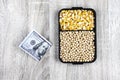 Top view mockup of 100 dollar banknotes and samples of soybean and corn seeds,