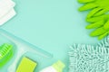 Top view mockup green cleaning supplies isolated on blue background. Flat lay frame with copy space Royalty Free Stock Photo