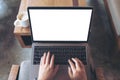 Business woman using and typing on laptop with blank white desktop screen , sitting on wooden chair in cafe Royalty Free Stock Photo