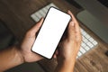 Top view Mockup image hand using a smartphone man Holding Cell Phone With Blank Screen