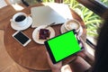 Top view mockup image of hands holding black tablet pc with blank green screen Royalty Free Stock Photo