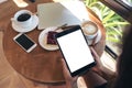 Top view mockup image of hands holding black tablet pc with blank white screen Royalty Free Stock Photo