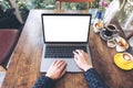 Top view mockup image of hands using and typing on laptop with blank white desktop screen and coffee cups Royalty Free Stock Photo