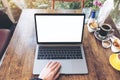 Top view mockup image of hands using and typing on laptop with blank white desktop screen and coffee cups Royalty Free Stock Photo