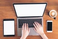 Top view mockup image of hands using and typing on laptop with blank white screen , tablet pc , mobile phone and coffee cup Royalty Free Stock Photo