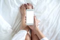 Top view mockup image of a woman`s hand holding white mobile phone with blank desktop screen Royalty Free Stock Photo