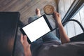 woman's hands holding black tablet pc with blank white screen while drinking coffee in cafe Royalty Free Stock Photo