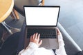 Woman`s hands using and typing on laptop with blank white desktop screen while sitting in cafe Royalty Free Stock Photo