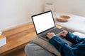 Top view mockup image of a woman working and typing on laptop computer with blank screen while sitting on a sofa at home Royalty Free Stock Photo