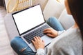 A woman working and typing on laptop computer with blank screen while sitting on a sofa at home Royalty Free Stock Photo