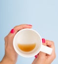 Top view mockup woman with red manicure nails holds with an almost empty mug with coffee isolated on blue. Flat lay with Royalty Free Stock Photo