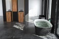 Top view of modern bathroom with black walls, concrete floor, bathtub filled with water, Royalty Free Stock Photo