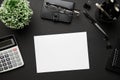 Top view of modern black office desk with blank paper sheet, notebook, pen and a lot of things. Flat lay table layout. Copy space Royalty Free Stock Photo