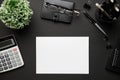 Top view of modern black office desk with blank paper sheet, notebook, pen and a lot of things. Flat lay table layout. Copy space Royalty Free Stock Photo