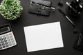 Top view of modern black office desk with blank paper sheet, notebook, pen and a lot of things. Flat lay table layout. Copy space Royalty Free Stock Photo