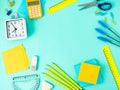 Top view of modern bright blue office desktop with school supplies on table around empty space for text. Back to school concept. Royalty Free Stock Photo