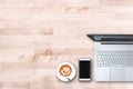 Top view of modern office workplace with computer laptop , smart phone , notebook paper , latte art coffee cup on wooden table Royalty Free Stock Photo