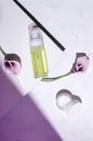 Top view of moisturizig products, calla flowers on the white surface, puprle light