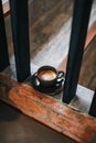 Top view morning hot coffee cup on vintage wooden staircase in cafe and restaurant.Hot cappuccino or latte coffee in black ceramic