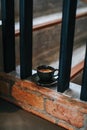 Top view morning hot coffee cup on vintage wooden staircase in cafe and restaurant.Hot cappuccino or latte coffee in black ceramic