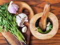 Top view of mortar with cilantro herb and garlic