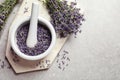 Top view of mortar and pestle with lavender flowers on grey stone background. Natural cosmetic