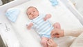 Top view of mother dressing her little baby son and stroking him on changing table. Concept of babies and newborn Royalty Free Stock Photo