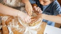 Top view on mother and little son mixing dough for biscuits in glass bowl. Children cooking with parents, little chef