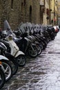 Florence, Italy - August 30 2023: Motorcycles and motor scooters parked in a row on a sidewalk. Royalty Free Stock Photo