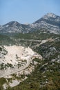 Top view of a mountain serpentine road on a mountain wasteland with green trees and mountain views. Royalty Free Stock Photo