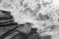 Top view on moving sea water against rocks with waves and foam, texture background pattern in black and white Royalty Free Stock Photo