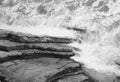 Top view on moving sea water against rocks with waves and foam, texture background pattern in black and white Royalty Free Stock Photo