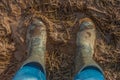 Close Up of Wellington Boots in a Muddy Field Viewed from Above Royalty Free Stock Photo