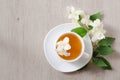 Top view of a mug of herbal tea and jasmine flowers on a wooden table, space for text Royalty Free Stock Photo