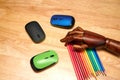 Top view of multi-colored pencils, computer mouses with an articulated wooden hand