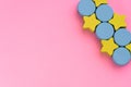 Top view on multicolored kids toys on light pink paper background. Wooden green stars, blue circles in right above corner. Copy Royalty Free Stock Photo