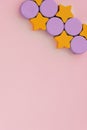 Top view on multicolored kids toys on light pink paper background. Wooden orange stars, lilac circles. Copy space for Royalty Free Stock Photo