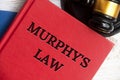 Top view of Murphy's Law book on wooden table with gavel background.