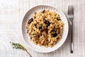 Top view of mushroom barley risotto or orzotto in a white plate on a line tablecloth. Royalty Free Stock Photo