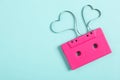 Top view of music cassette and hearts made with tape on turquoise background, space for text. Listening love song